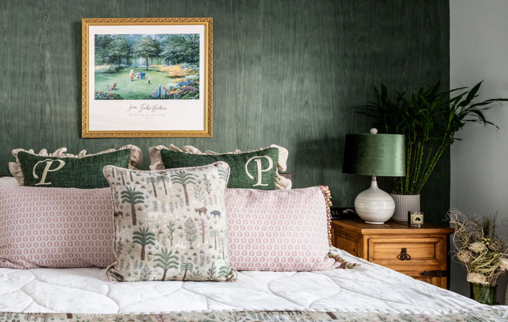 Bedroom interior design with warm green wallpaper, soft textiles and houseplants