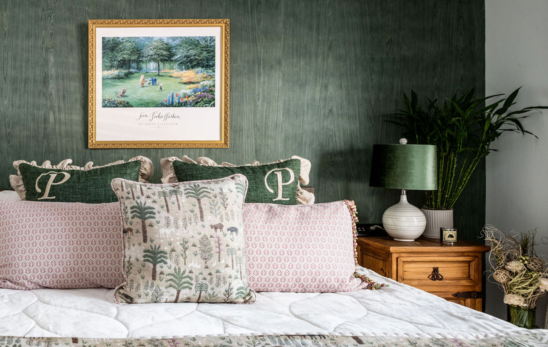 Bedroom interior design with warm green wallpaper, soft textiles and houseplants